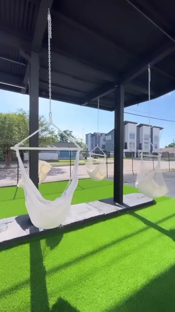 Video: white hammock chairs swaying under the covered pavilion on the turf yard